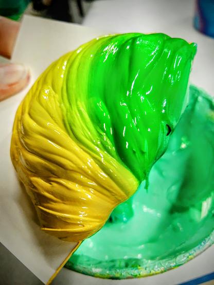 A poofy blob of ink that's been scraped from a screen. The ink was used to print a gradient that transitions from yellow to green