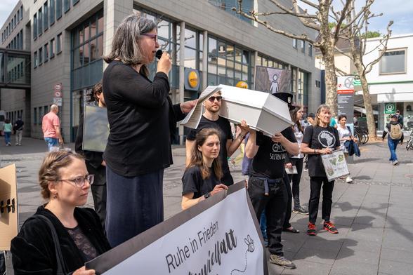 Mahnwache in der Mainzer Innenstadt. Schwarzgekleidete Menschen, die BUND Landesvorsitzende Sabine Yacoub verliest die Trauerrrede.