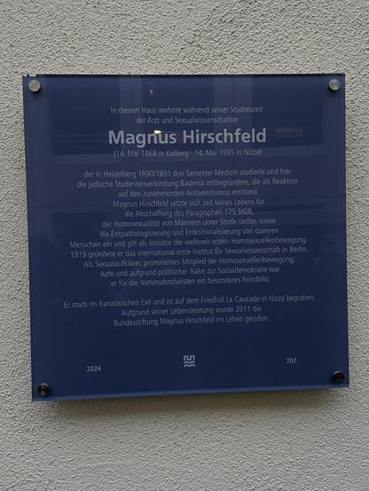A blue plaque commemorating Magnus Hirschfeld, a physician and sexologist, who lived in this house during his studies. It details his contributions to the LGBTQ+ movement, including his efforts to abolish Paragraph 175, which criminalized homosexuality in Germany