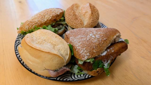 Ein großer flacher Teller mit 4 unterschiedlichen geformten Fischbrötchen.