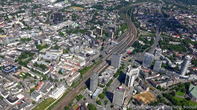An aerial photo of the Essen central station with the center of essen next to it. There is a big black building in the top left which is the city hall of essen.