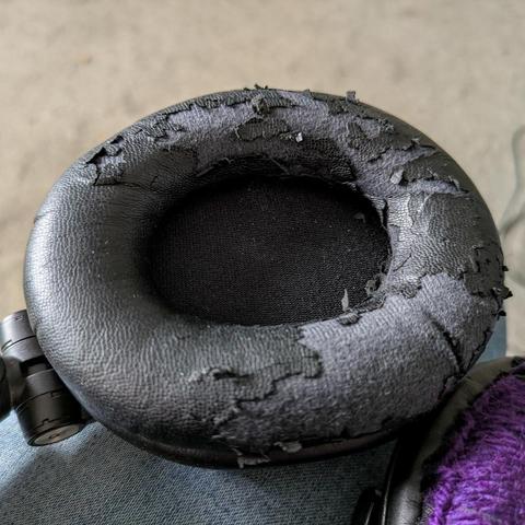 An earphone covered in fake leather that's flaking off.