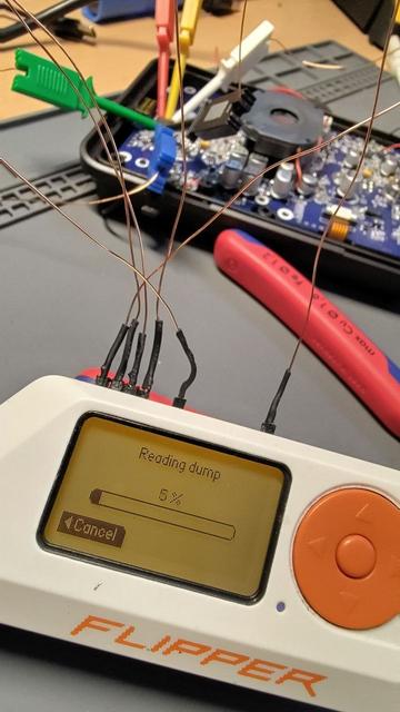 Flipper Zero which shows:
"Reading dumo
5%"

In the background is some hardware which the Flipper  Zero is conncted