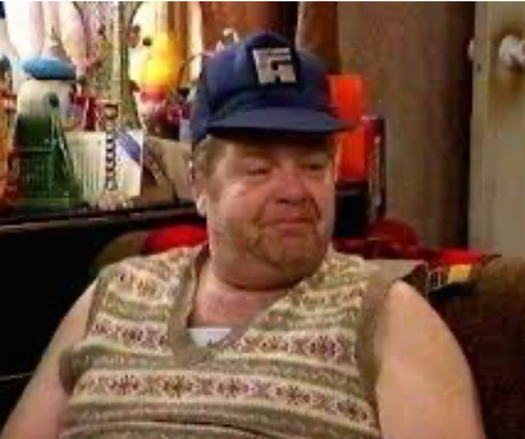 Image of the actor playing the character Onslow on the TV series “Keeping up Appearances.” He is unshaven, wearing a vest without a shirt underneath.