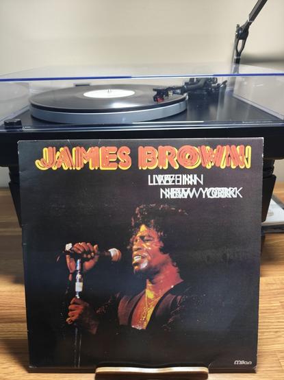 Album cover of James Brown's "Live in New York" album in front of a turntable playing the album.