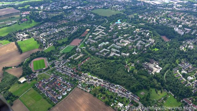 An aerial photo of Freisenbruch, a living quater at the edge of the city to the border of Bochum, with many trees and farm yard around.