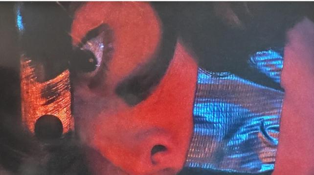 View of Scully's head. She's face down. She's got a black mark under her eyes and silver masking tape over her mouth.