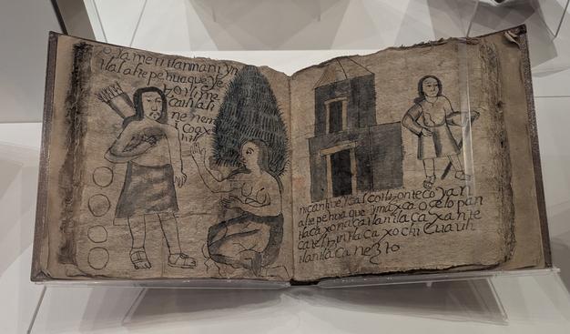 An open book, the pages showing mostly taken up with illustrations of a man with a quiver and a kneeling woman (on the left) and of a man with a staff standing in front of a building (on the right). The paper is rough and greyish brown.