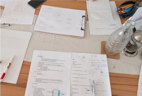 A table with papers and pens on it