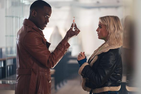 Ncuti Gatwa's Doctor standing face to face with Ruby Sunday, holding a little vial his hand and presenting it to her, as she is looking at him curiously.