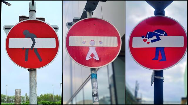 Three no entry signs which have been altered with vinyl stickers to show a stick figure messing with the central bar.