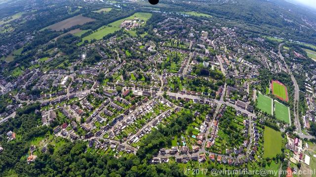An aerial photo of Essen Überruhr with big living quaters in a green landscape with many trees.