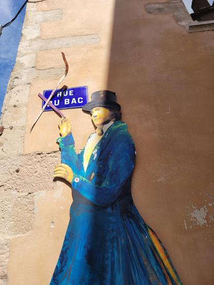 Personnage avec haut-de-forme peint et fixé sur un mur, rue du bac à Tournus