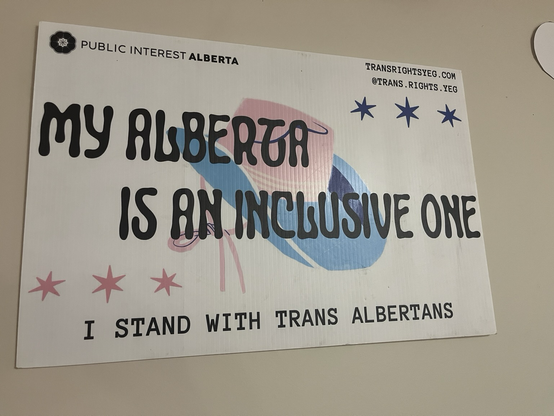 A pink and blue poster reads, My Alberta is an Inclusive One: I stand with trans Albertans.