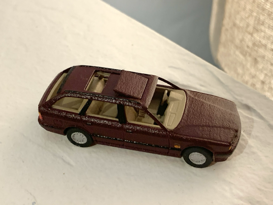 A burgundy 3D-printed 1:64-scale BMW 525iT with the rear panel of its dual-panel sunroof open.