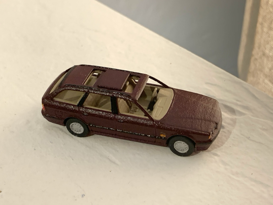 A burgundy 3D-printed 1:64-scale BMW 525iT with both panels of its dual-panel sunroof open.