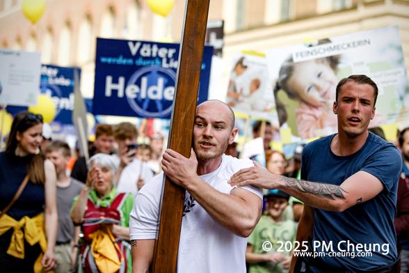 Ein männlicher Teilnehmer, der ein Kreuz trug, gleich daneben ein weitere Teilnehmer, der offenbar nicht fotografiert werden wollte.