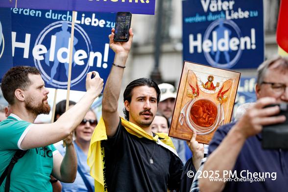 Von solchen komischen Demonstrant*innen gab es beim Marsch zuhauf. Hier hält ein Teilnehmer ein Bild, in der anderen Hand sein Smartphone.