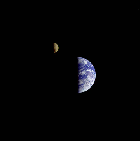 Adapted from source linked in toot: the first image of the Earth-Moon system in a single photographic frame taken by Voyager 1 as it departed on its journey to explore Jupiter and Saturn. 

Both the earth and moon are seen with their right halves illuminated. The earth is in the center and the moon is slightly above and to the left of the earth.