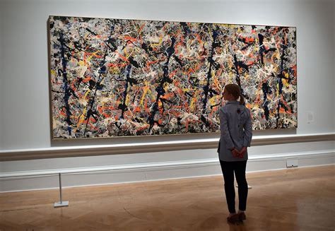 A person admires Blue Poles from afar.  As a young Art student I crept right up close to take a look at the brush strokes. And to my surprise, flakes of paint gathered beneath the painting. It looks like you can’t do it now.