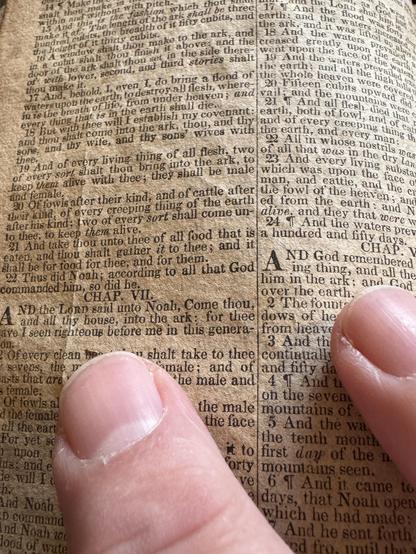 Page of Bible from 1827 in tiny type with fingers on top for scale