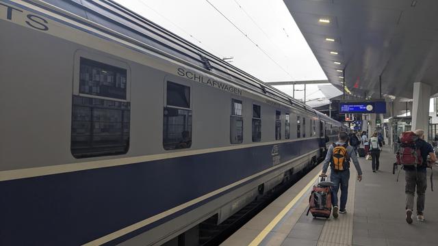A CFR wagon-lits carriage with people leaving the train in Vienna.