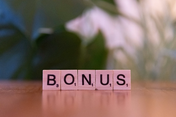 Het woord Bonus gespeld met Scrabble-letters.