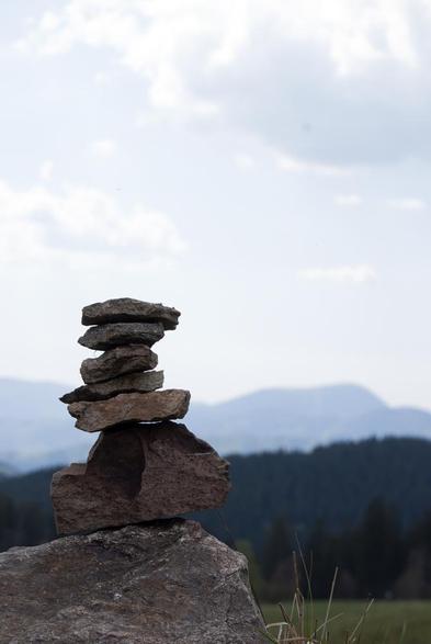 A stone stack in front of a blurred mountain silhouette