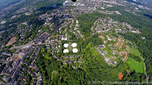 An aerial photo of Essen Bredeney. You can see multiple living quaters sourrounded by many trees. There are four silos in the middle of the image.