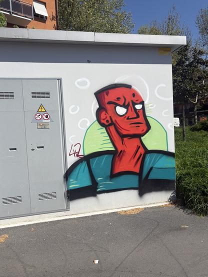Testa rossa di uomo dipinta su una cabina del telefono