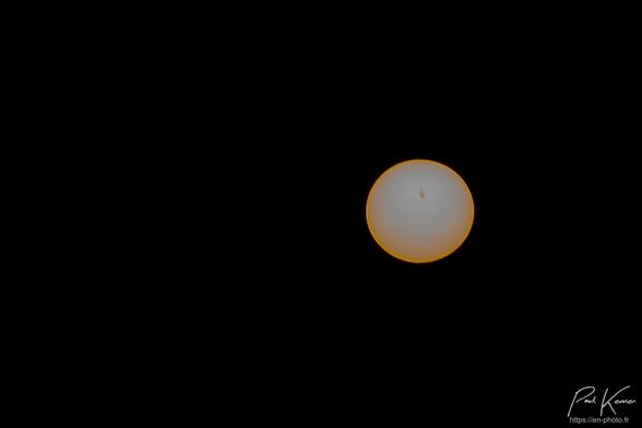 Photo du soleil avec un filtre ND 1000 qui ne laisse passer que 1/1000 de la lumière où l'on perçoit une grosse tache solaire ou sunspot