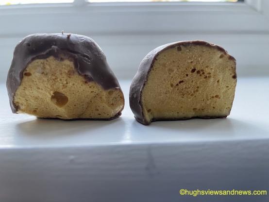 A photo of chocolate-covered honeycomb chunks, where one of the chunks looks a little like Darth Vader.