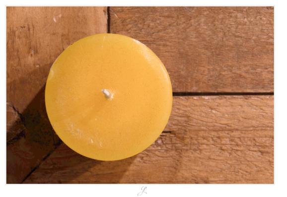 Close-up of a new, unlit candle from above. The wax is a warm yellow color, the wick is white. The candle stands on a light brown wooden table with a strong grain. The gaps between the joint edges of the wooden top and the frame form a 90° angle. The joint edge of the frame itself forms an angle of 45°. The candle is positioned so that the wick is exactly at the point where all the joints meet.

AI disclaimer: Using my work, its meta data, written or derived description to create media with or train AI based systems is prohibited.
