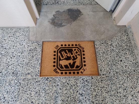 Eine Kokos-Fußmatte vor der Eingangstür zum Space mit dem UNHB-Logo