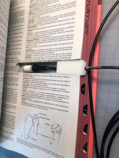 A discarded book with a small chunk cut out of the textblock to hold a sensor in the interior of the book.