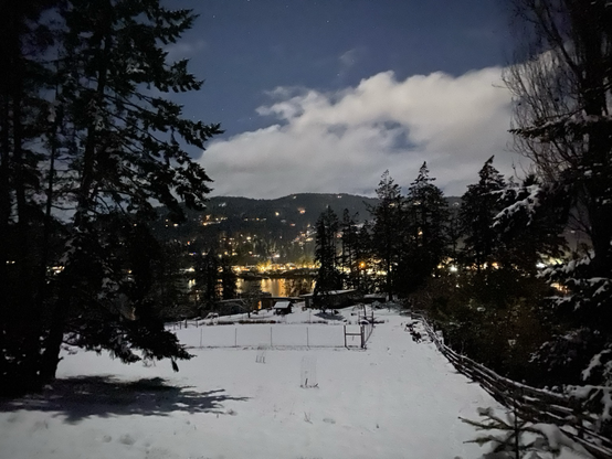 Moonlight shot with a long exposure. We look across an ocean bay to a silent village.
