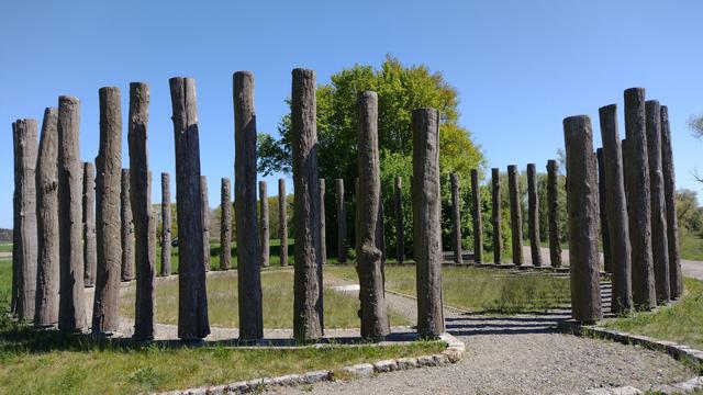 Abgebildet ist die Nachbildung ein Kreises aus 56 Holzpfosten, der in der Frühbronzezeit, um 1800 vor Christus, südlich Gartow (NO-Niedersachsen) im Elbtal errichtet wurde. Der Holzkreis wird "Woodhenge" genannt.