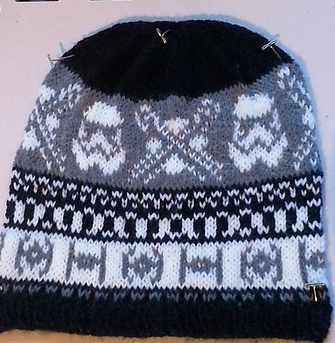 A knit hat, in black white and grey, with a star wars motif. Posted in celebration of star wars day.