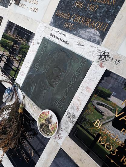Une photo de l'emplacement des cendres de Nestor Makhno, où on voit plein de petits tags écrits autour.
