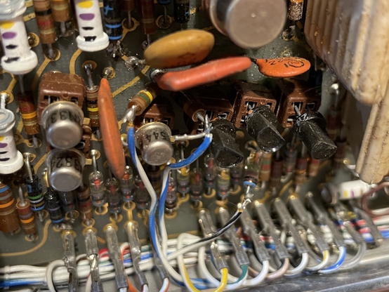 A close up of a 1960s circuit board with modifications done; resistors sticking straight up, connected to wires pulled out of a loom