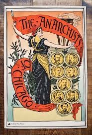 Woman holding a long red banner that reads "The Anarchists of Chicago," with small, medallion busts of the 8 men convicted of the Haymarket bombing.