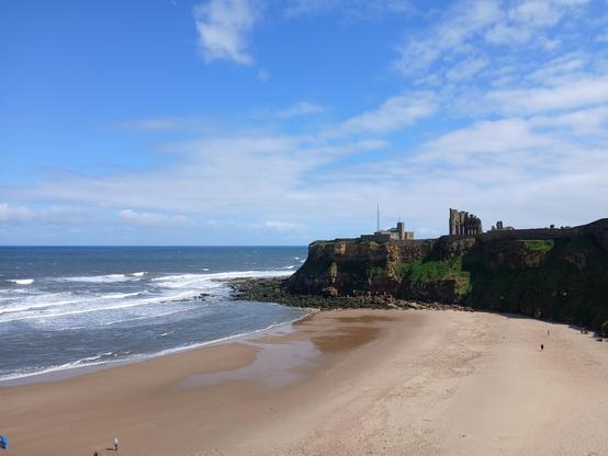 King Edward's Bay. There is golden sand, the north sea, and the ruins of tynemouth priory on top of a cliff
