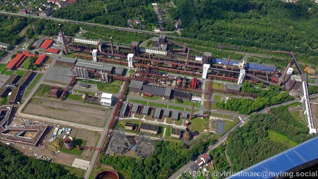 An aerial photo of the coking plant of the UNESCO world heritage site Zollverein, sourrounded by trees.