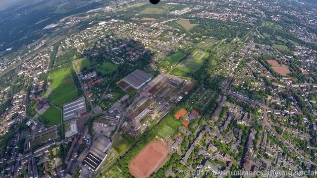 An aerial photo of the center of gelsenkirchen with working quaters and some living quaters, all sourrounded by trees.