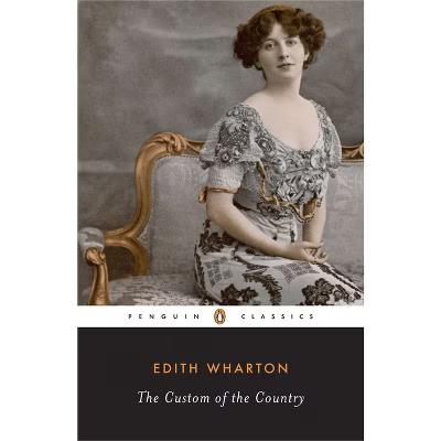 The image features a book cover for "The Custom of the Country" by Edith Wharton, published by Penguin Classics. The cover displays a sepia-toned photograph of a woman seated on an ornate, upholstered chair with a gold-accented frame. The woman is wearing an elaborate, Victorian-style dress with intricate lace and beadwork, featuring a low neckline and short sleeves. Her hair is styled in soft curls, and she has a composed expression. The background is a muted gray, providing a neutral backdrop that highlights the subject. The title and author's name are presented in a simple, elegant font against a dark background at the bottom of the cover. The Penguin Classics logo is visible at the top, indicating the book's series.

Provided by @altbot
