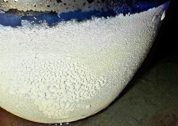 Ice condensing on the outside of a frozen glass tumbler filled with subzero Jägermeißter resembles an ice moon.