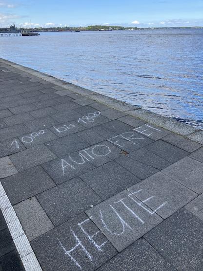 Auf dem Fußweg am Wasser steht mit Kreide: Autofrei heute 10-18 Uhr