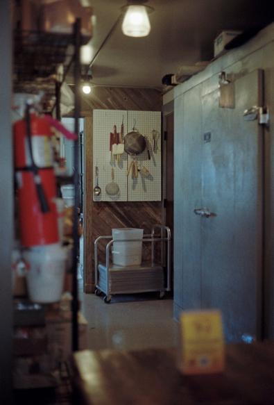 Cooking tools hanging on a peg board at a bakery.