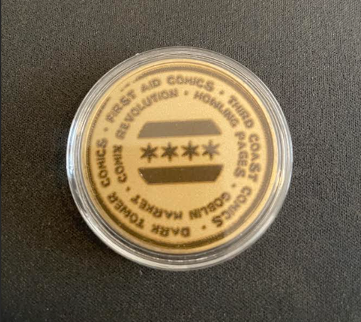Brass coin engraved with the flag of the City of Chicago in the center, ringed with the names of the following participating shops (clockwise from top, in two concentric circles) Outside Circle: First Aid Comics, Third Coast Comics, Dark Tower Comics. Inside Circle: Howling Pages, Goblin Market, Comix Revolution.