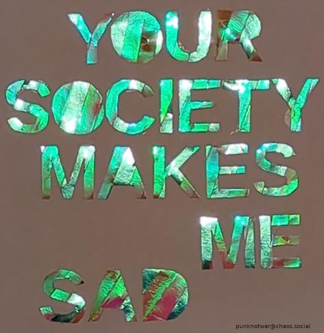 Ein leuchtend giftgrüner Schriftzug der schreibt: "Your Society Makes Me Sad"